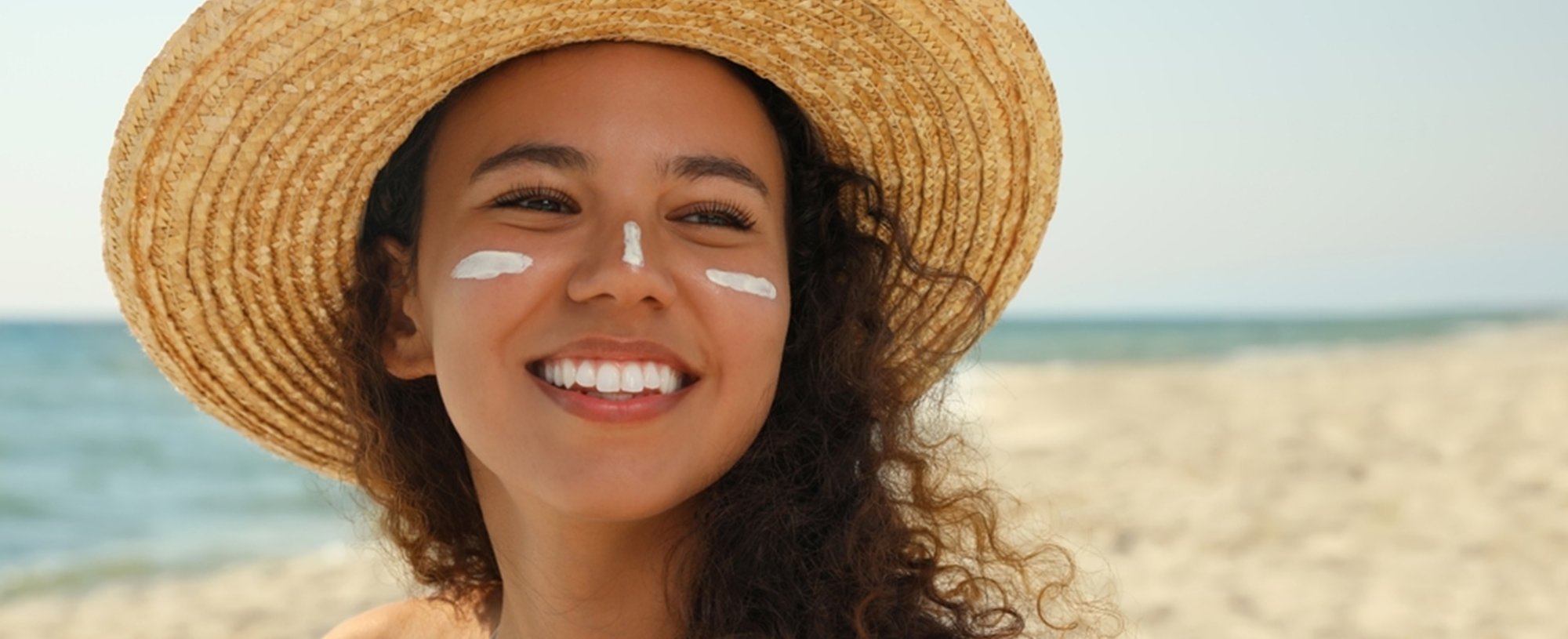 Modelo branca passando protetor solar no braço