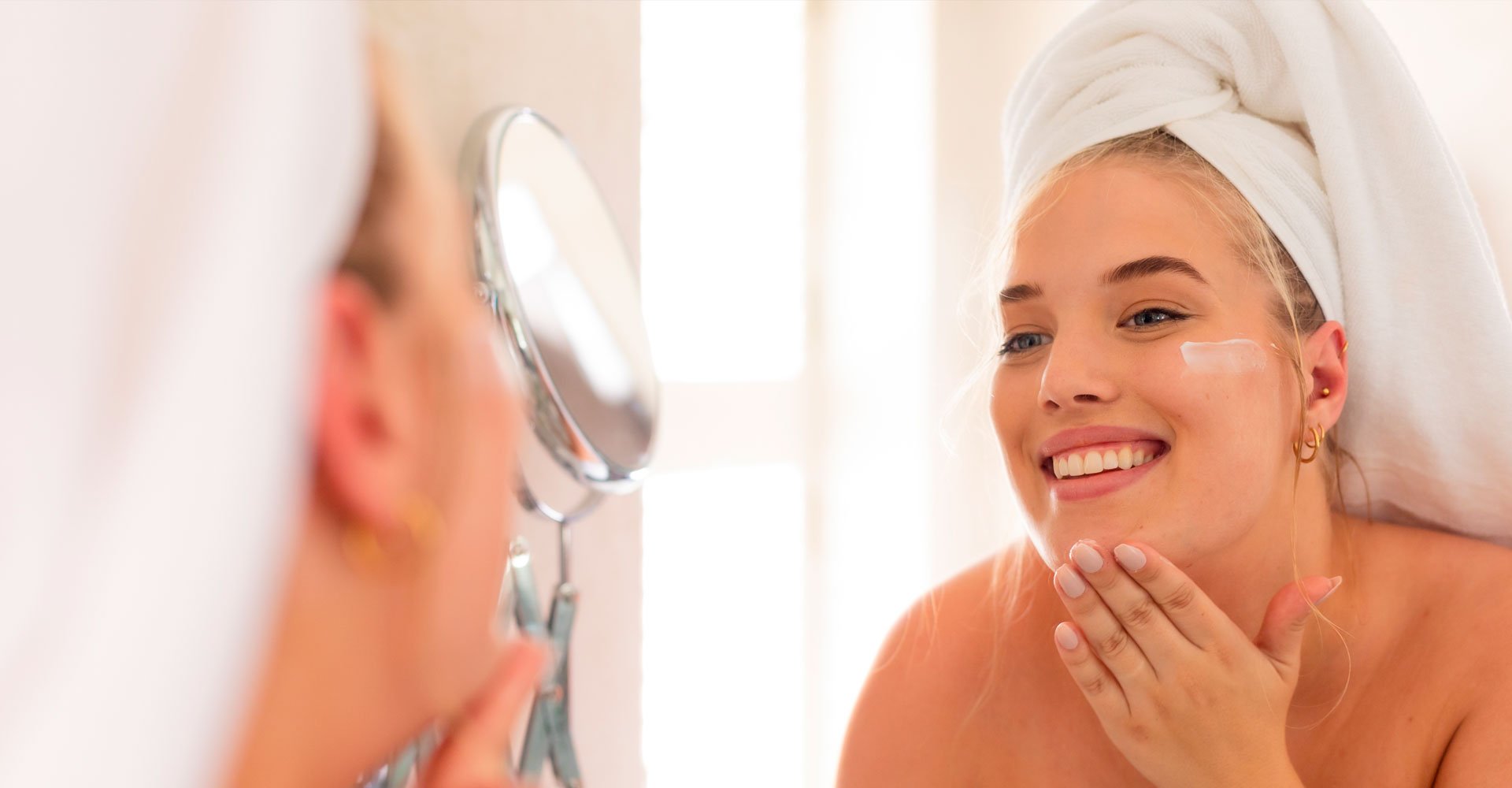 Mulher aplicando protetor solar facial para evitar o envelhecimento precoce