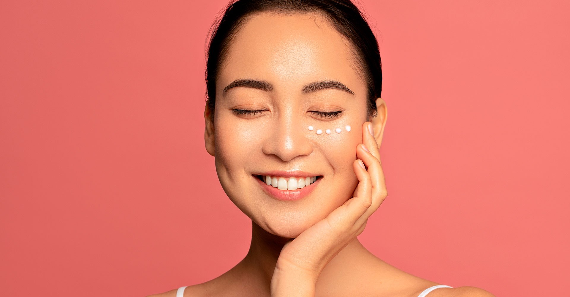 Mulher aplicando creme na região das olheiras