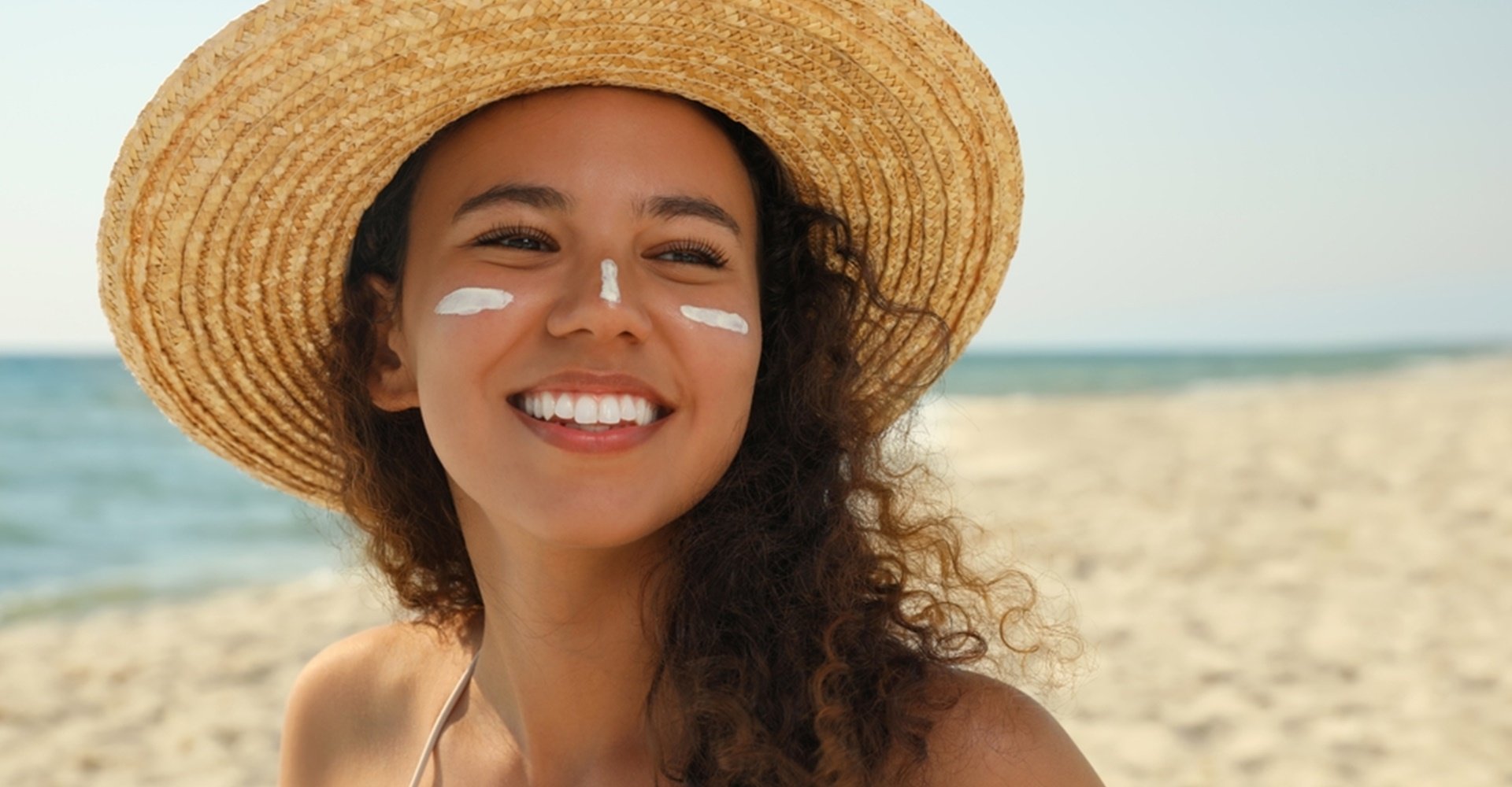 Modelo branca passando protetor solar no braço