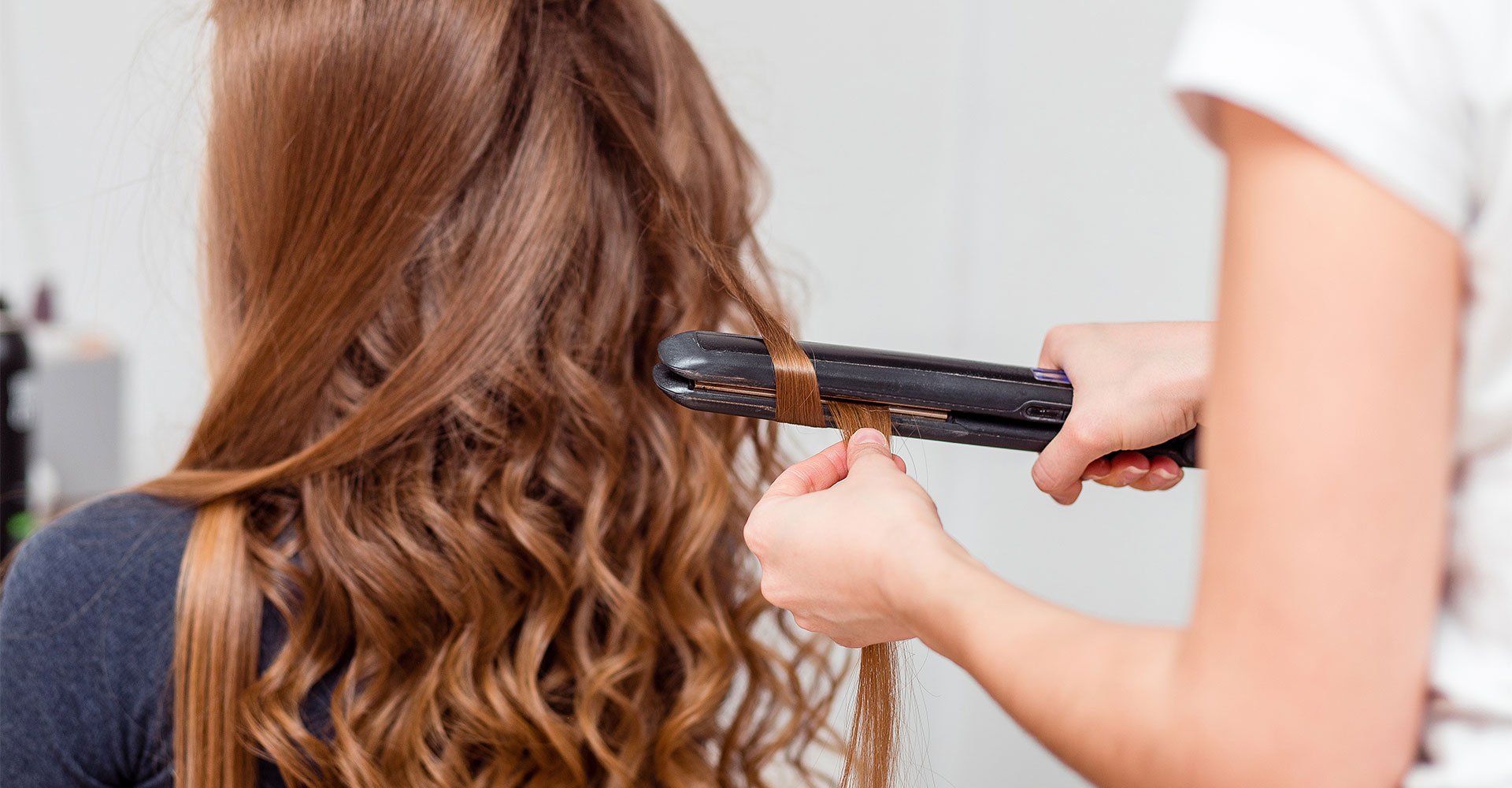 Profissional usa o modelador de cachos, ou babyliss, em sua cliente