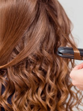 Profissional usa o modelador de cachos, ou babyliss, em sua cliente