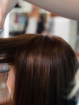 Profissional cabeleireiro realiza um corte de cabelo feminino curto que é tendência nos salões de beleza