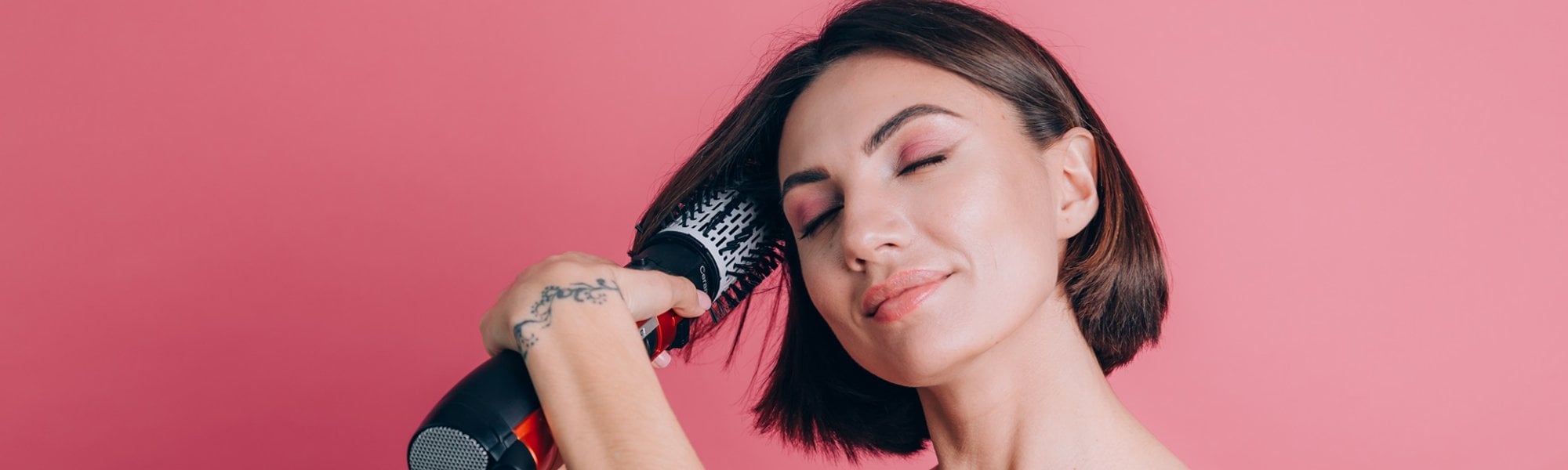 mulher de cabelo curto alisando o seu cabelo com uma escova alisadora