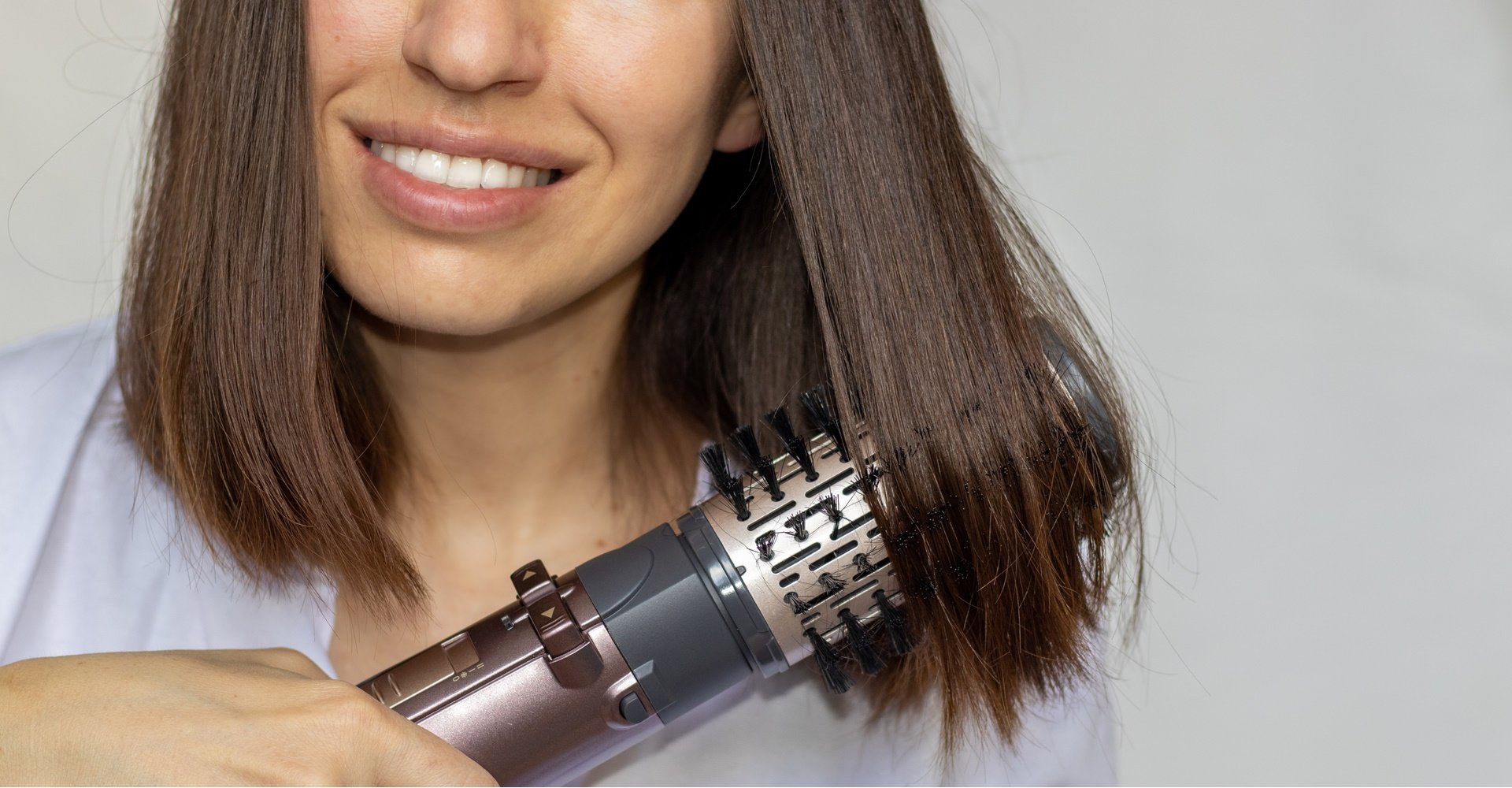 mulher parda usando escova modeladora em seu cabelo