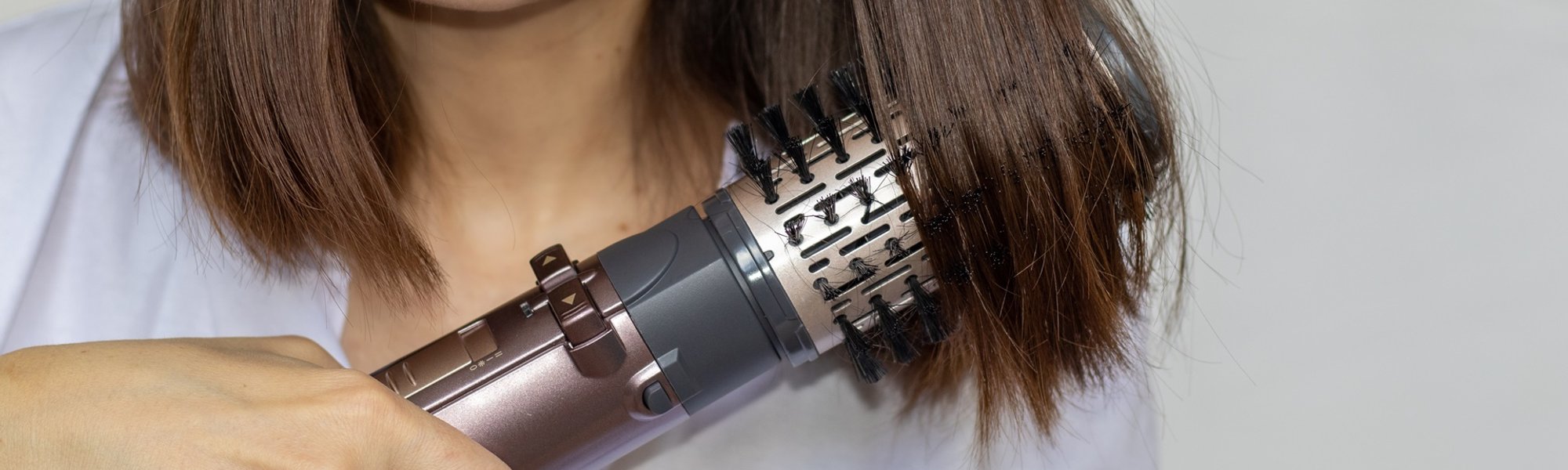 mulher parda usando escova modeladora em seu cabelo