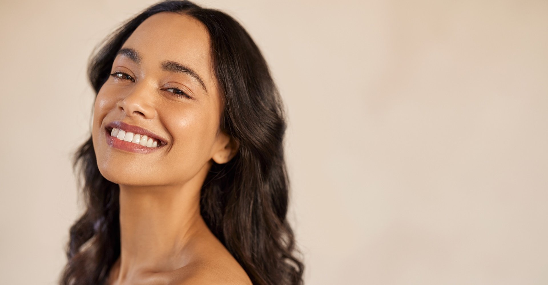 mulher de pele parda com cabelos lisos sorridente posando para a foto