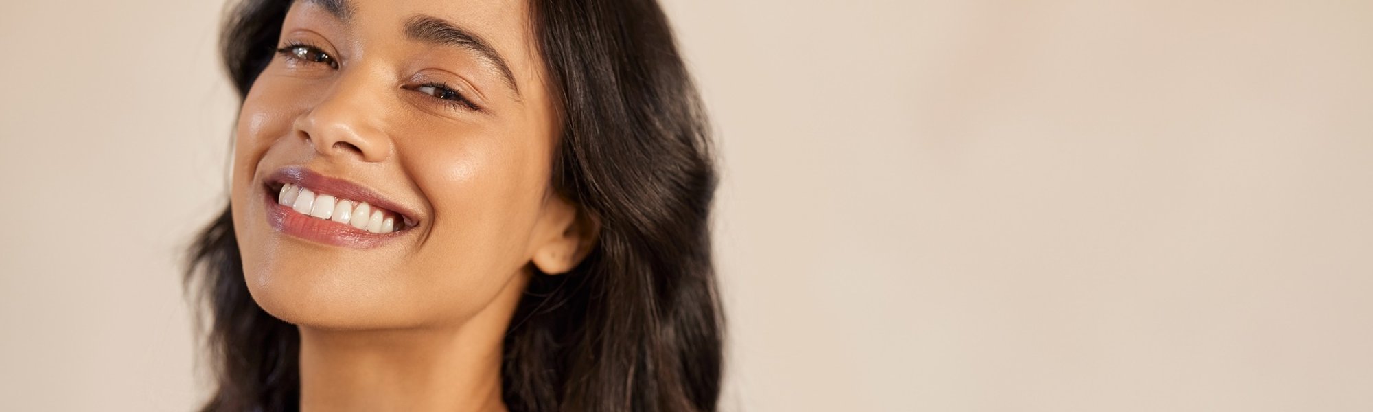 mulher de pele parda com cabelos lisos sorridente posando para a foto