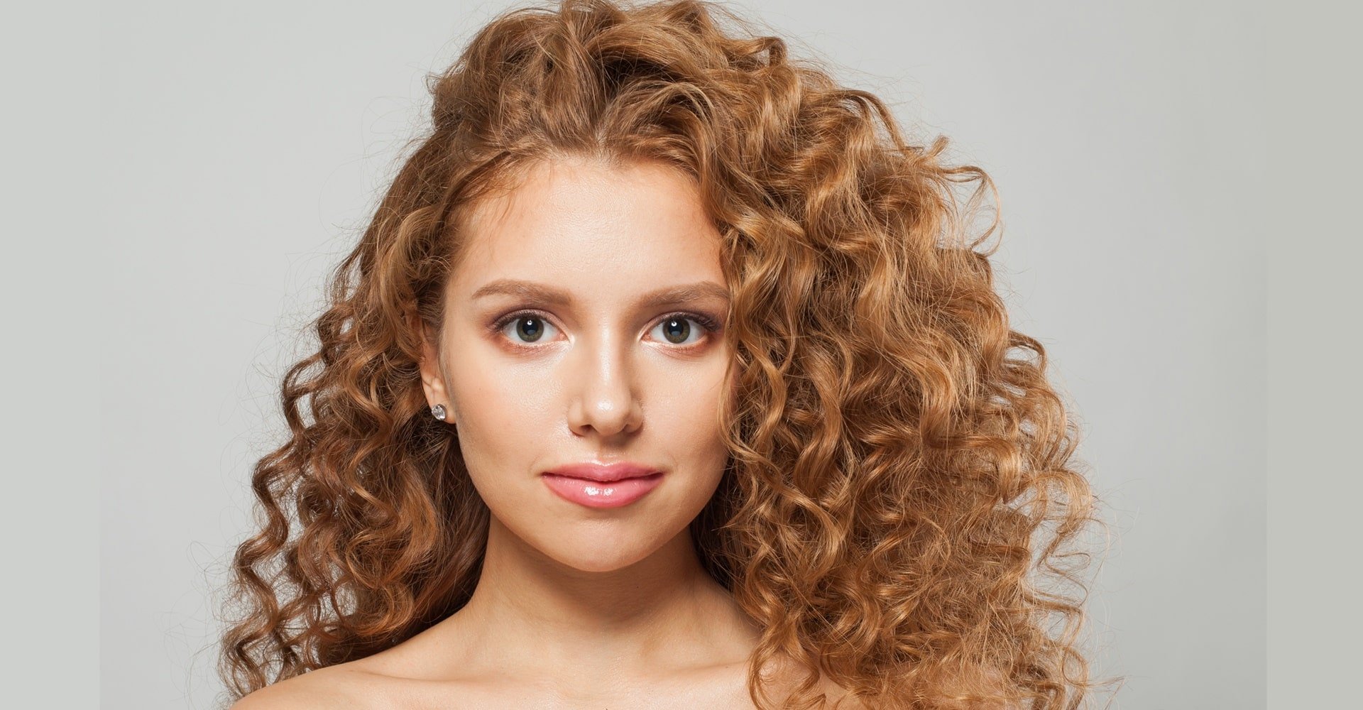 Ruiva com cabelo cacheado faz uso de mascara de nutrição capilar