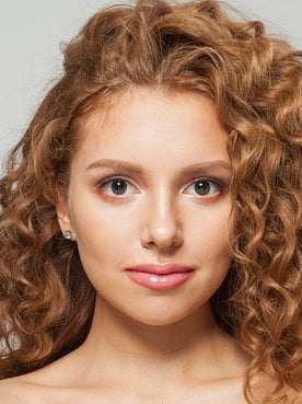 Ruiva com cabelo cacheado faz uso de mascara de nutrição capilar