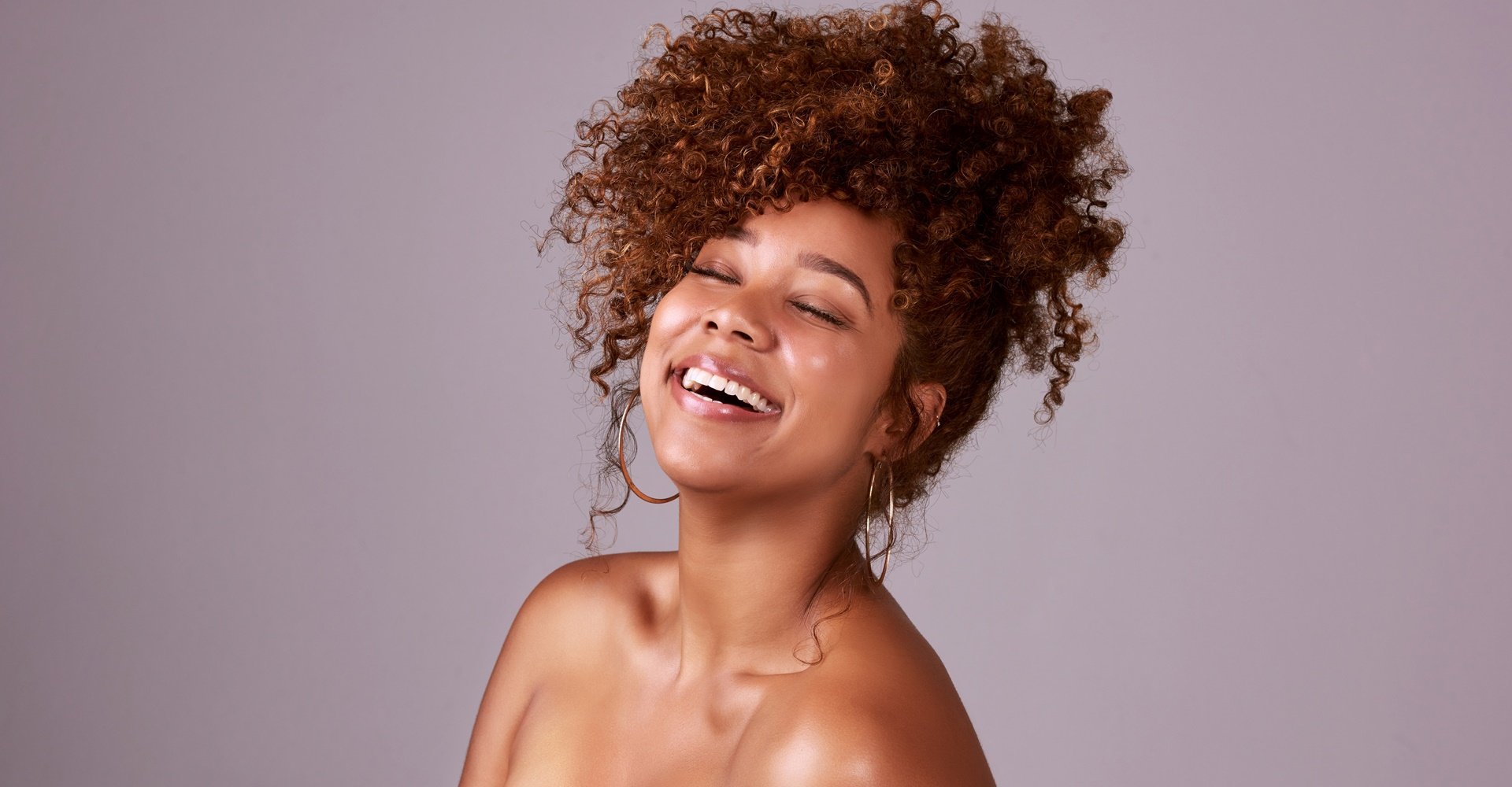 mulher negra com cabelo acobreados preso em um penteado alto