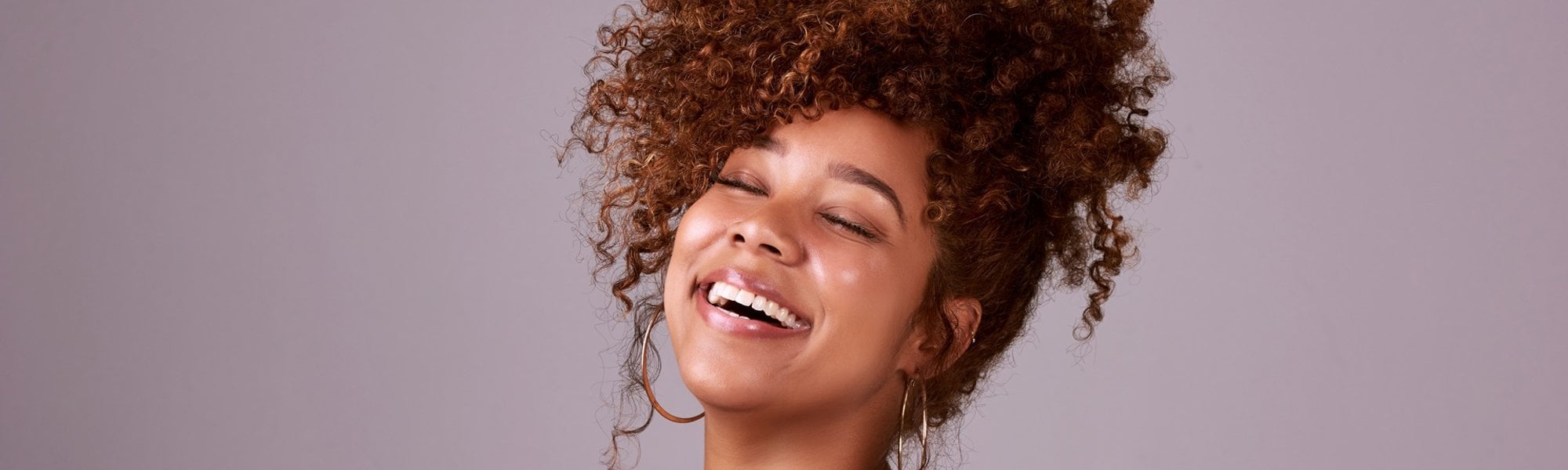 mulher negra com cabelo acobreados preso em um penteado alto