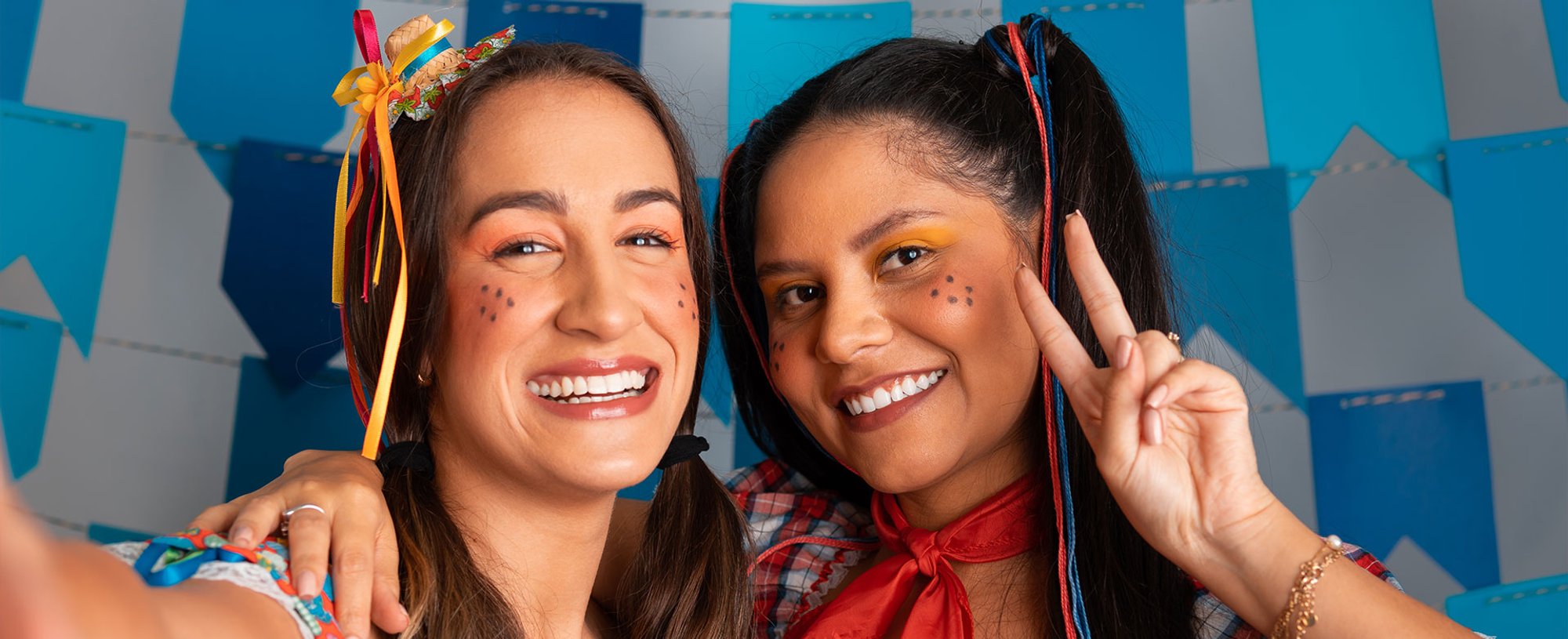 duas mulheres com roupas e penteados de festa junina