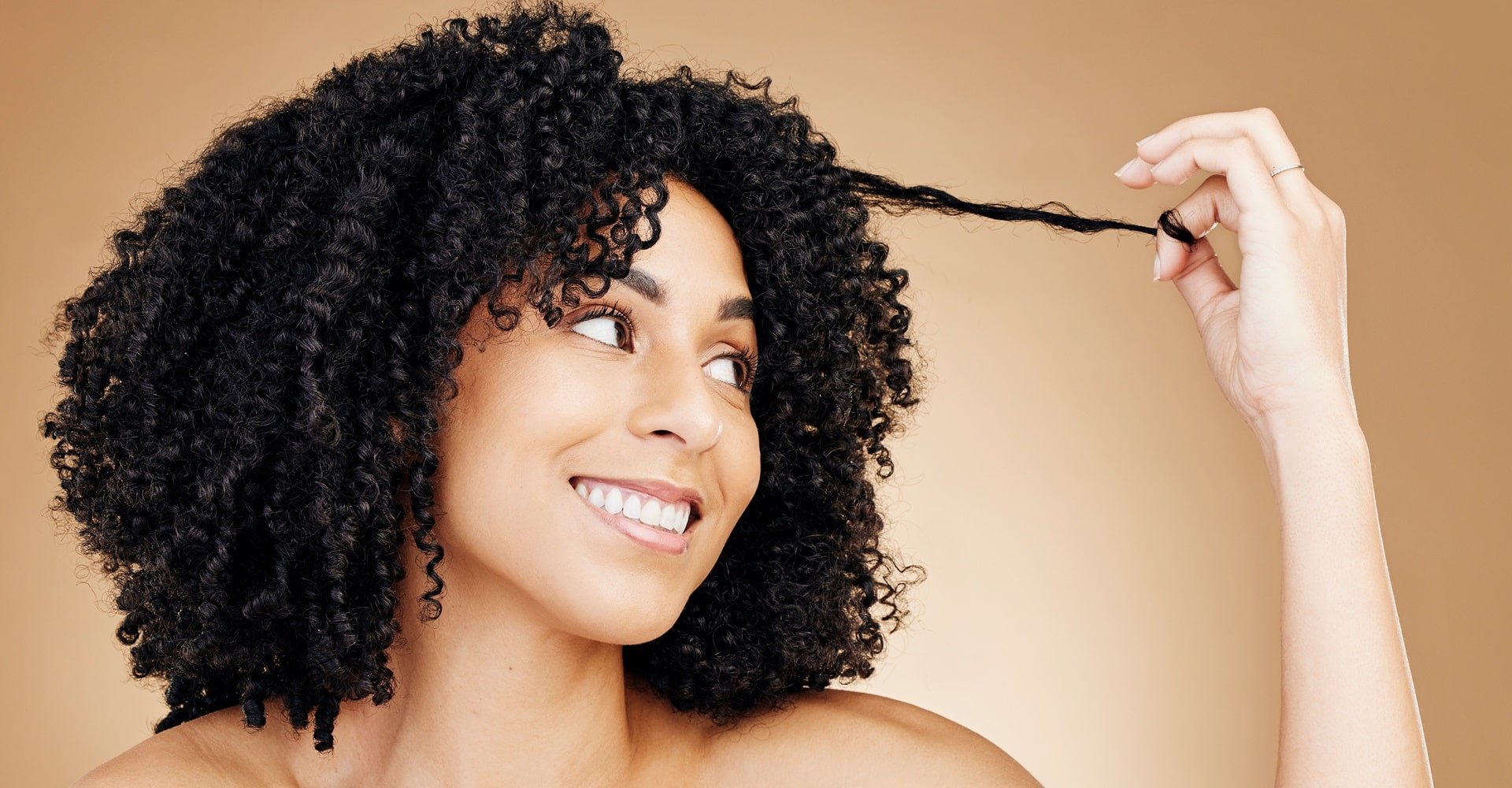 ulher observa seu cabelo que pode ser nutrido com um sérum capilar