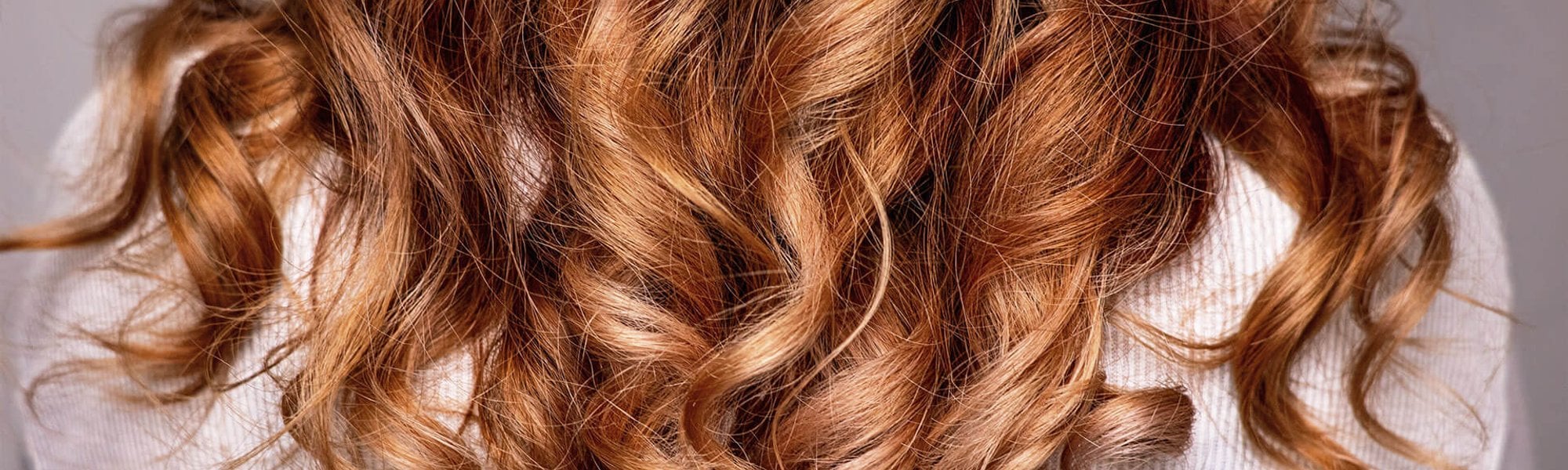 mulher com cabelo ondulados castanho avermelhado