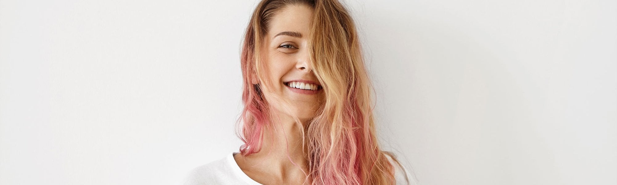 mulher branca de cabelo longo loiro com as pontas do cabelo rosa