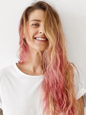 mulher branca de cabelo longo loiro com as pontas do cabelo rosa