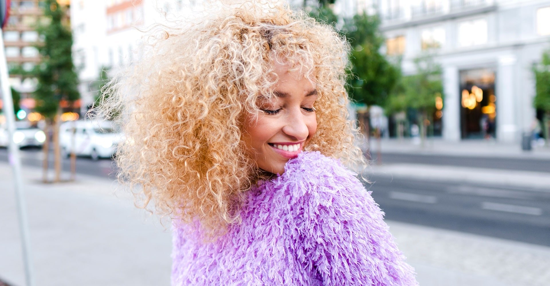 Mulher de cabelos cacheados com coloração de cabelo