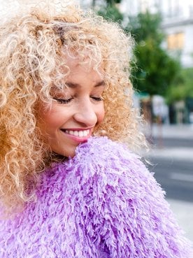 Mulher de cabelos cacheados com coloração de cabelo