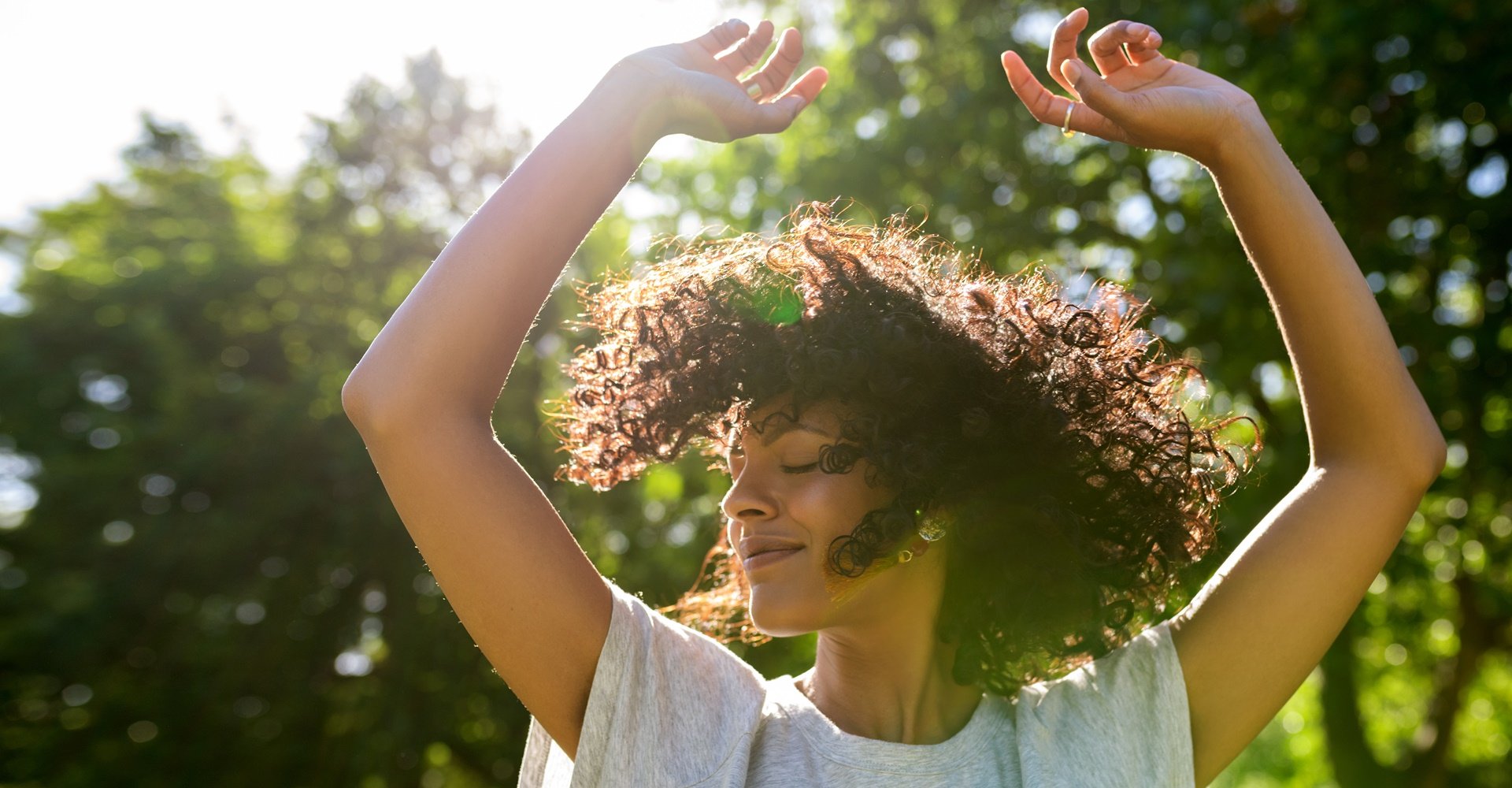 mulher com os cabelo cacheado ao vento