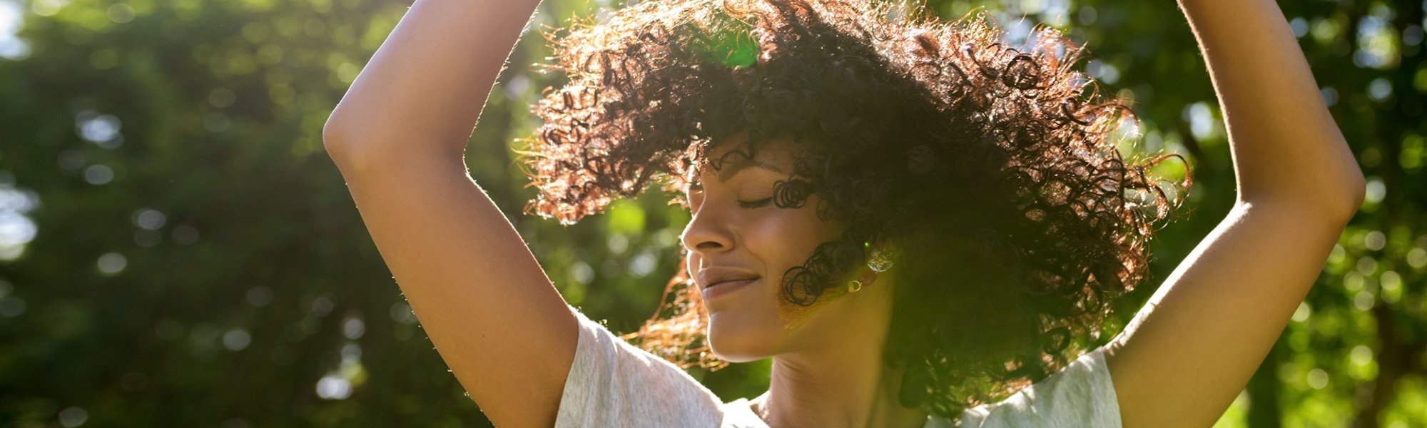 mulher com os cabelo cacheado ao vento