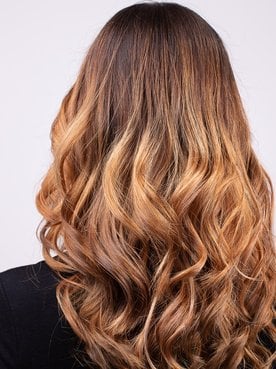 Cabelo ondulado de tonalidade loiro mel dourado
