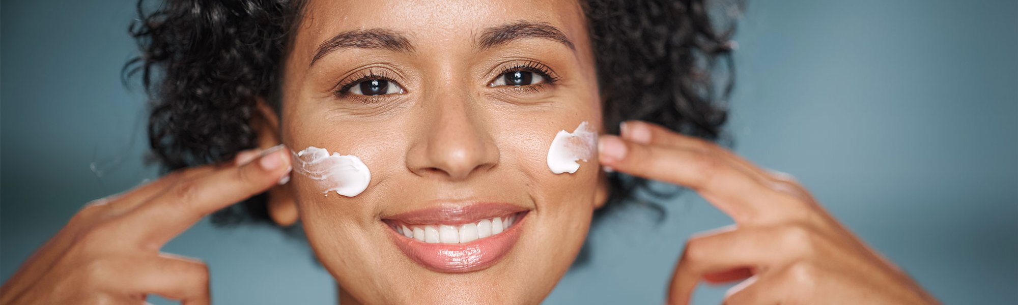 Mulher aplica produto que pode conter ácido glicólico e outros ativos na pele do rosto