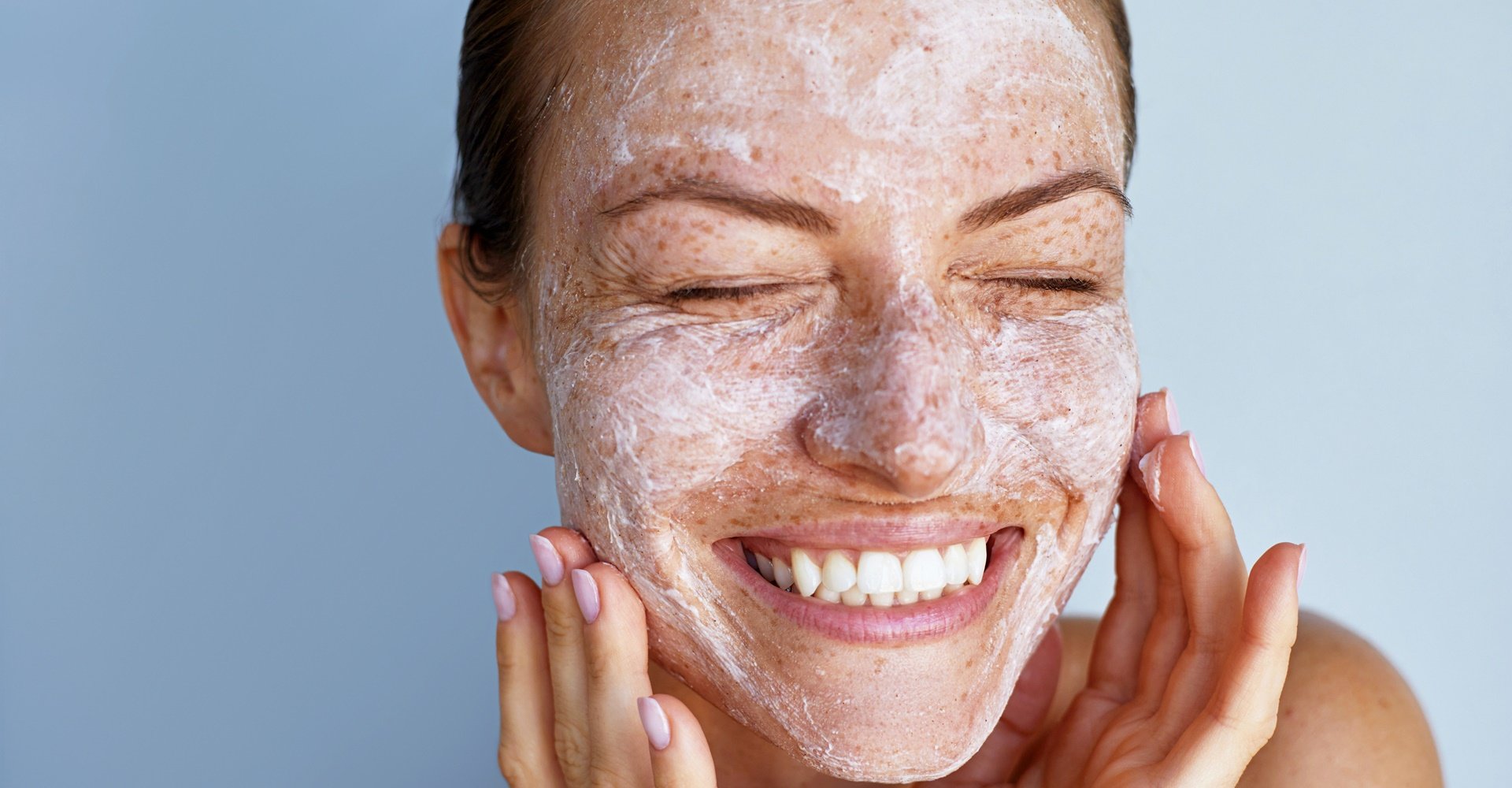 Mulher caucasiana usa um esfoliante para o rosto