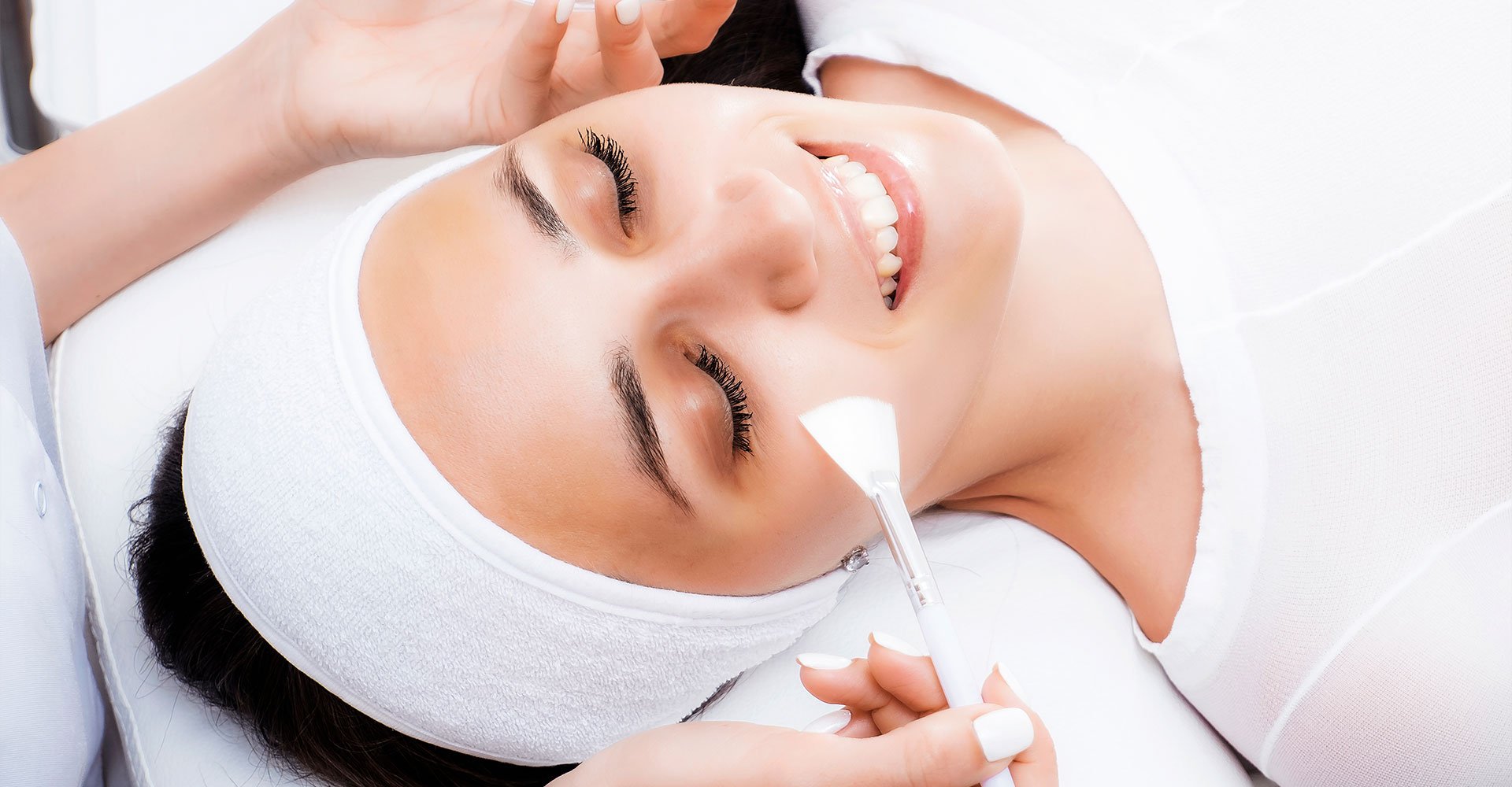 Mulher sorrindo ao fazer o tratamento de peeling facial que pode ser químico ou físico
