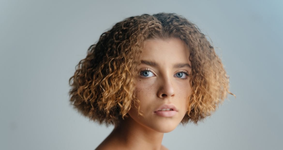 Mulher com cabelo crespo em corte short bob.