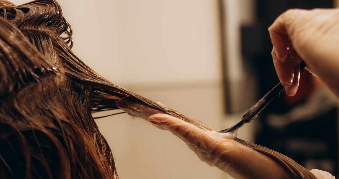 Profissional pintando o cabelo de sua cliente em um balayage