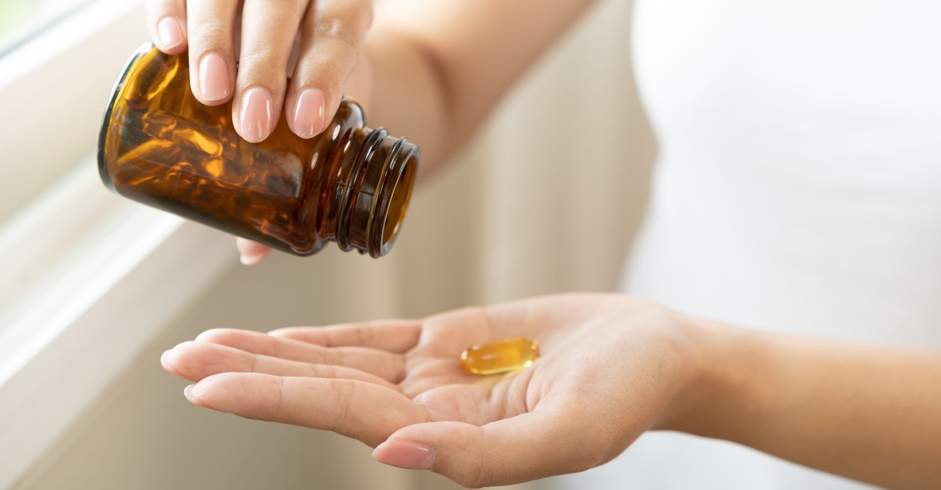 Mão com cápsula de biotina.