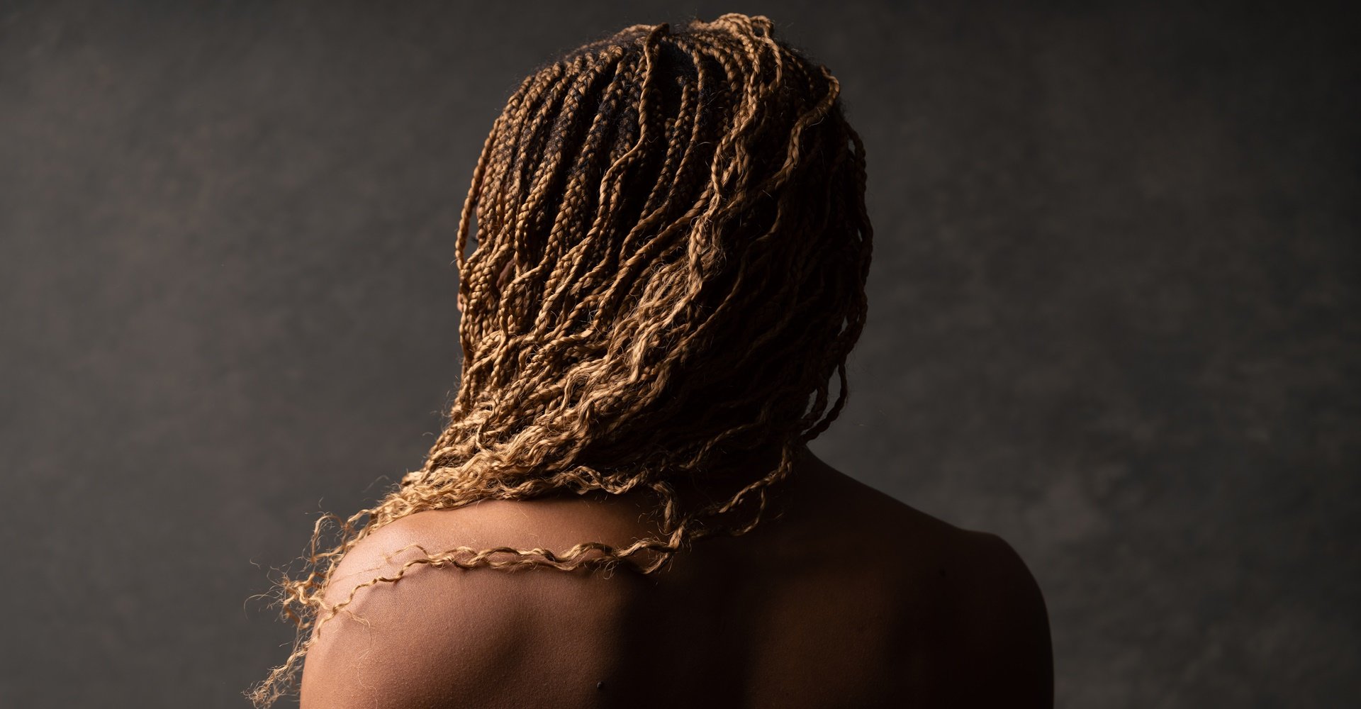 Jovem de costas mostrando seu estilo de tranças boho braids