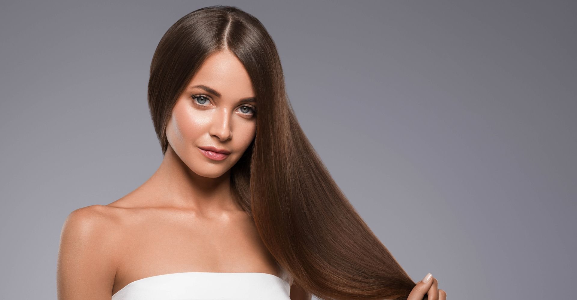 Mulher segurando seu cabelo longo após fazer hidratacao para cabelo em seus fios.