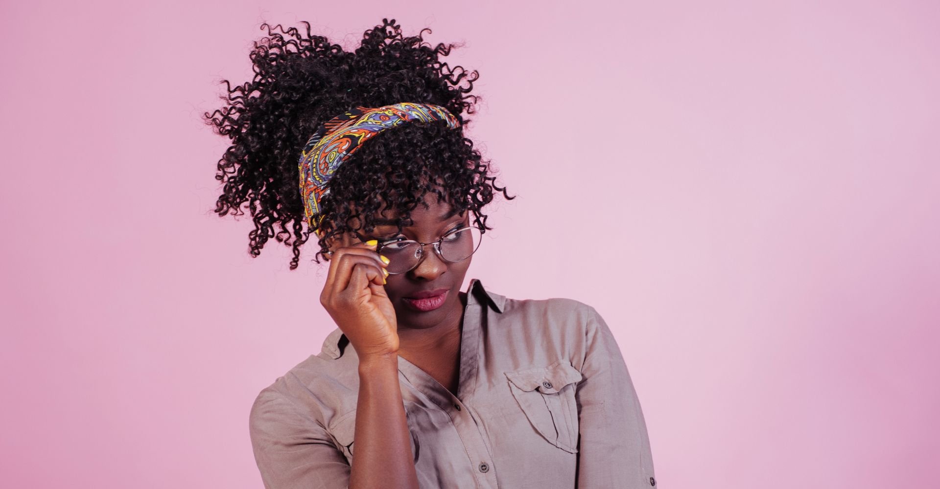 Mulher com bandana no seu cabelo cacheado curto.