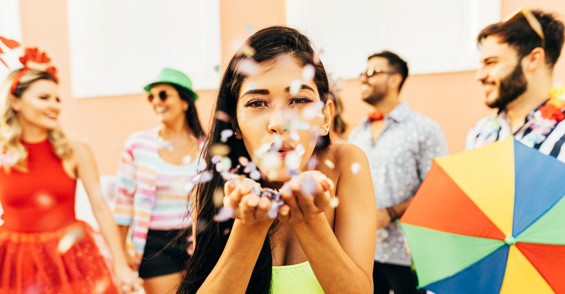 Menina soprando glitter no carnaval.