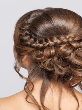 Mulher de costas com coque baixo com trança no cabelo.