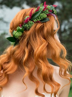 Mulher em uma floresta com penteado simples em seu cabelo ruivo.