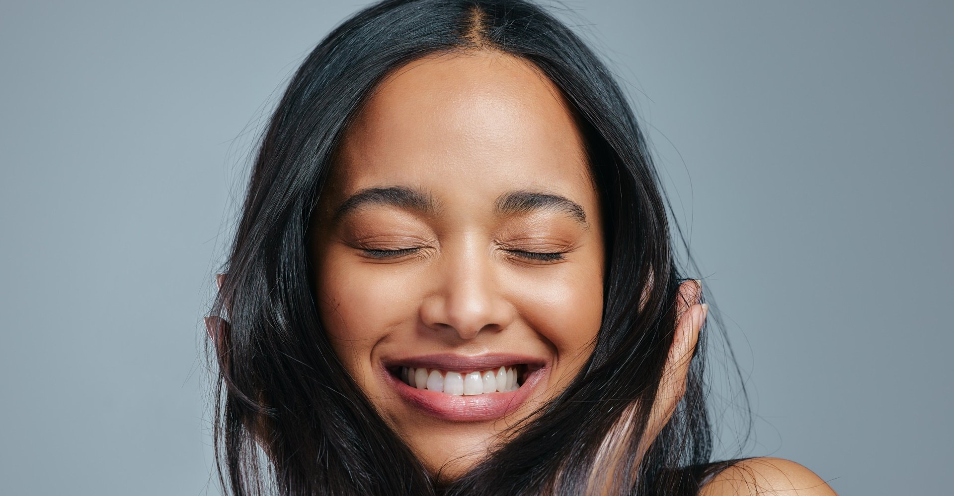 Mulher sorridente com cabelos lavados com shampoo para cabelo liso