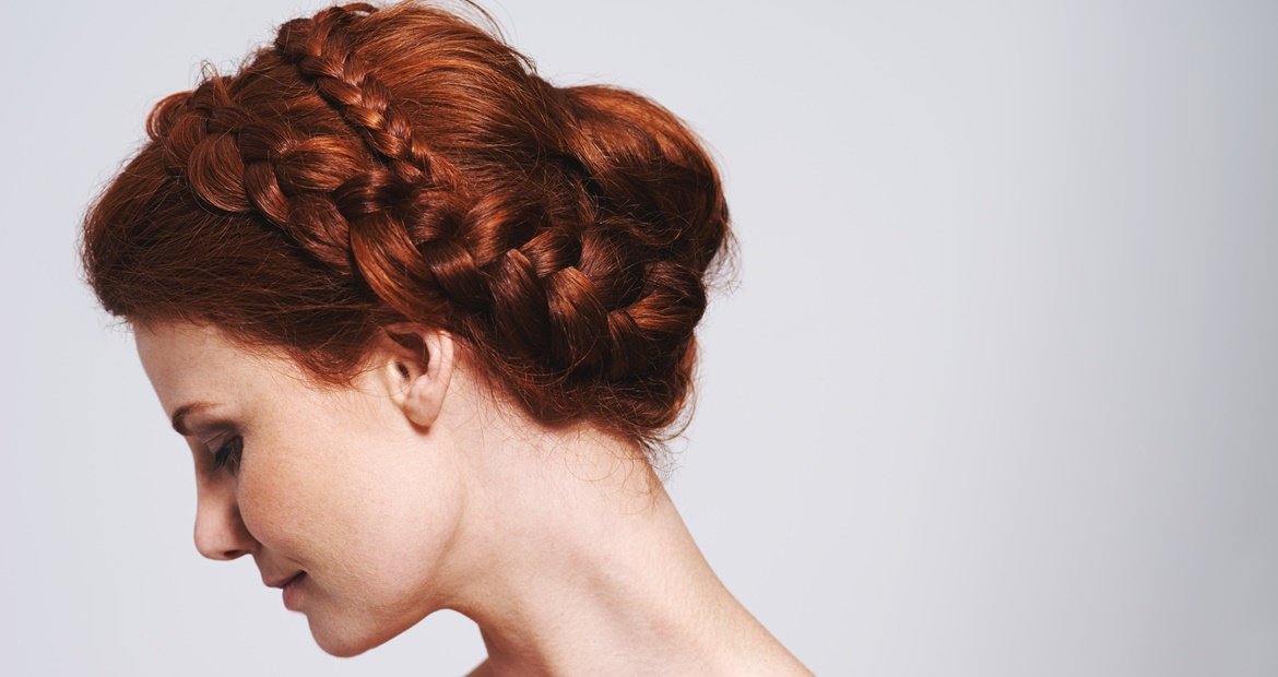Mulher com trança no cabelo curto ruivo.