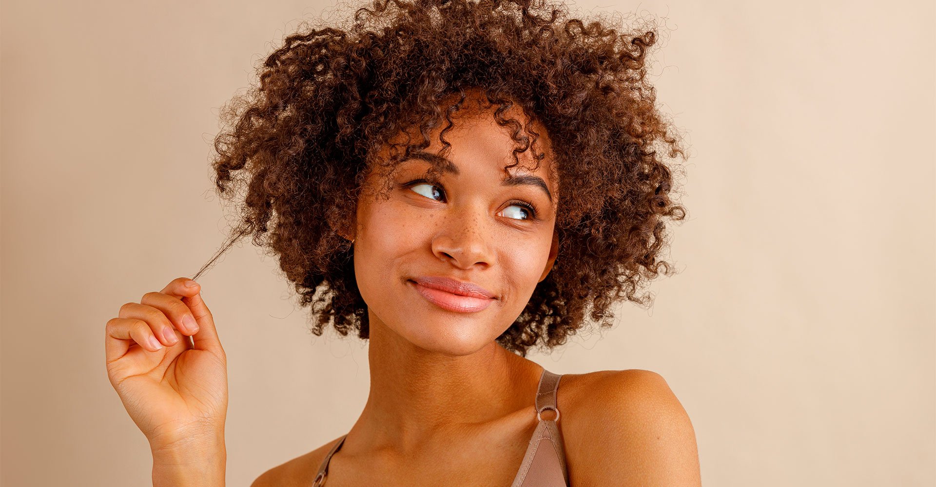 Mulher negra com cabelo cacheado após passar por transição capilar