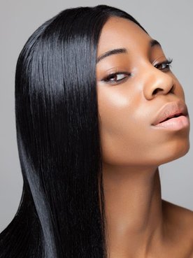 Mulher negra com cabelos coloridos e hidratados com ácido glicólico