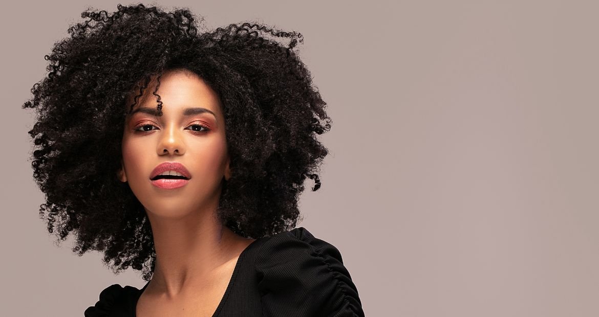 Jovem mulher negra com os cabelos pretos, característicos da cartela inverno brilhante
