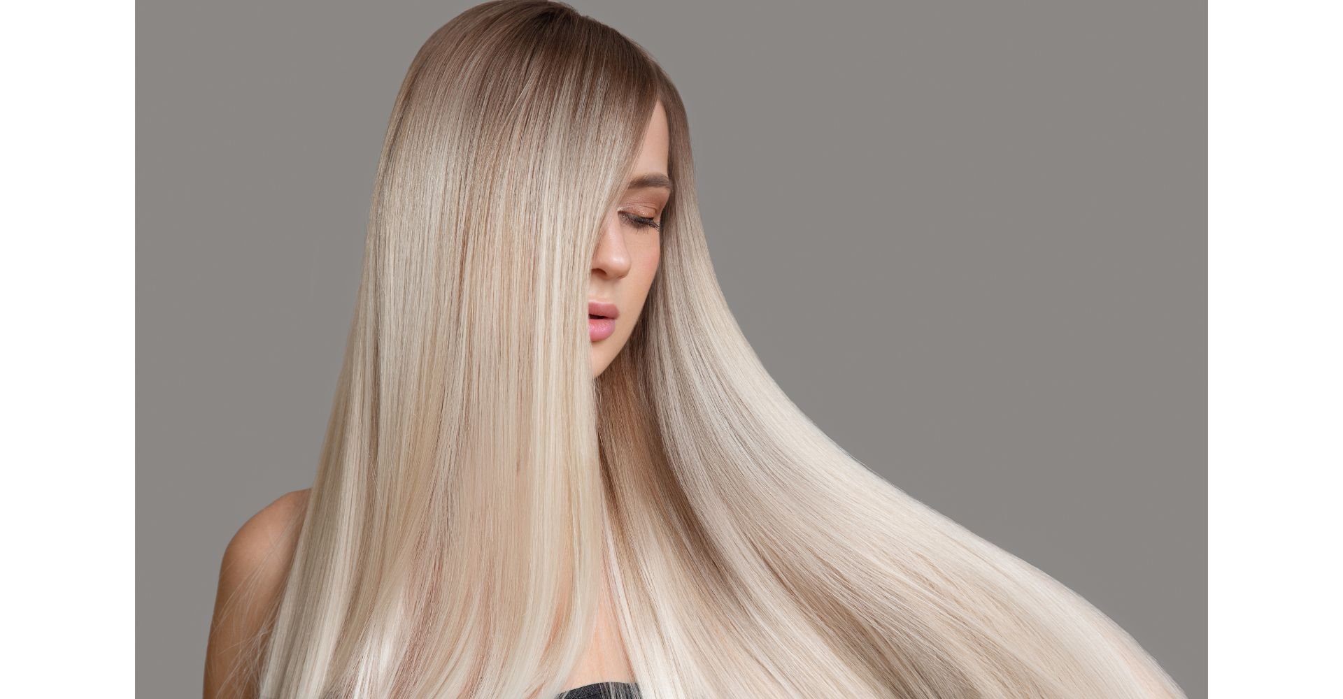 Mulher com loiro perolado com luzes em fundo cinza.