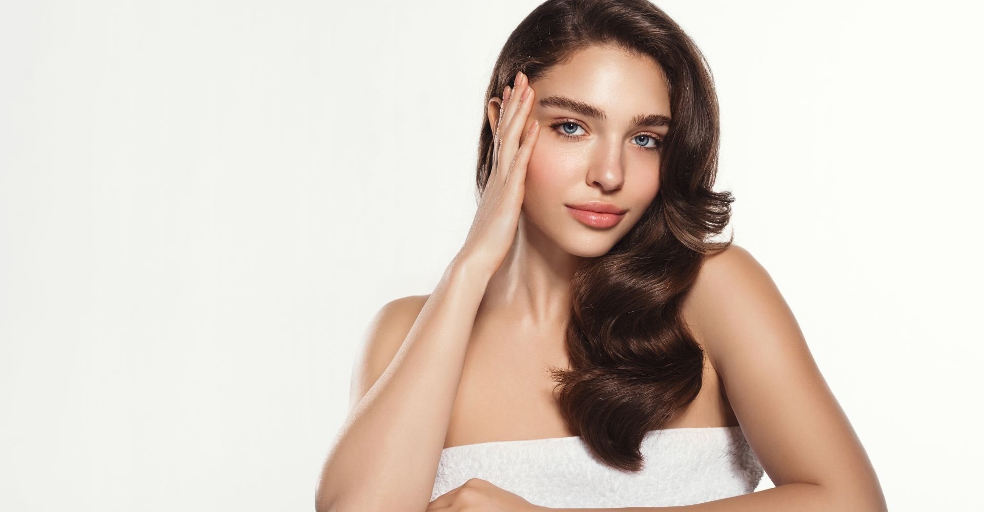 Menina com a mão no rosto com cabelo em tamanho médio com tom castanho natural.