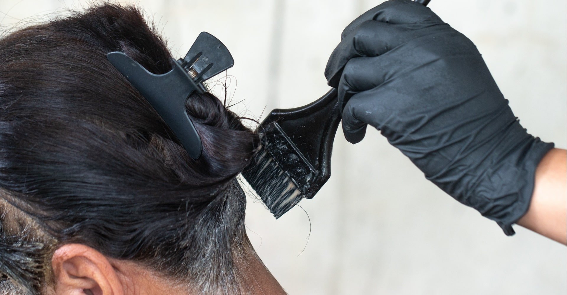 Mulher usando tonalizante preto no cabelo.