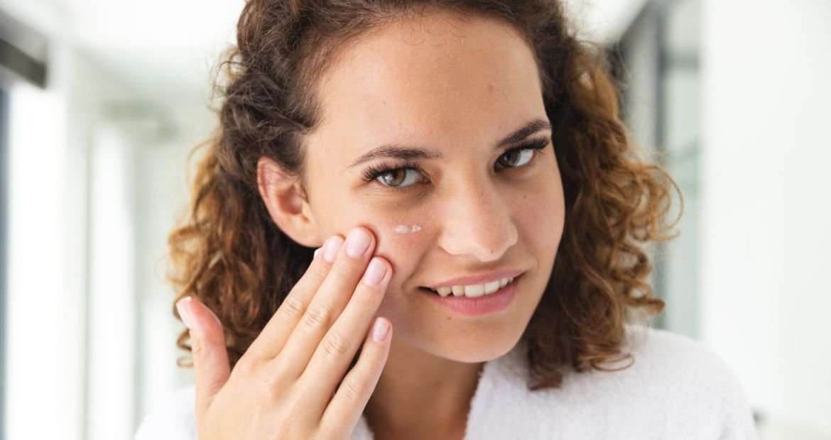Mulher caucasiana aplica um creme facial com ácido para o rosto
