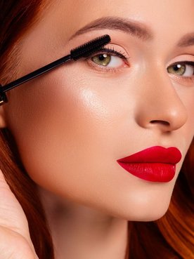Jovem mulher ruiva realiza blindagem na maquiagem para ter um visual impecável