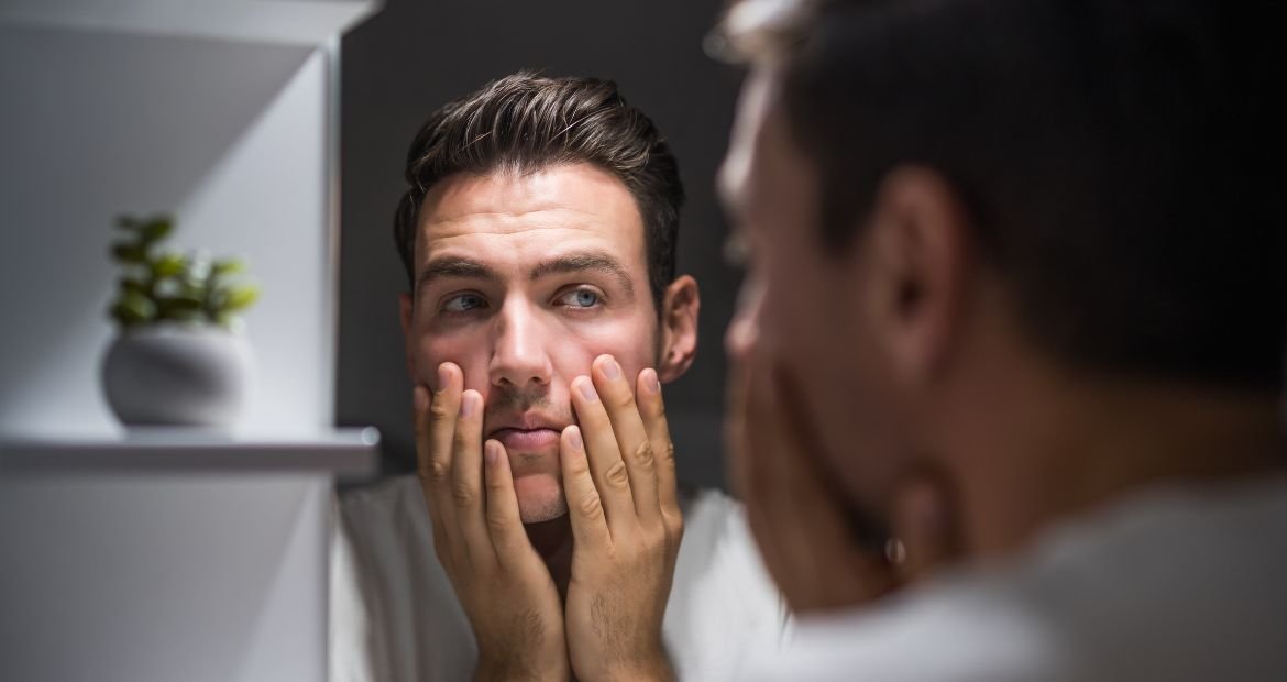 Homem considera usar creme para o rosto masculino com ação antissinais, antirrugas ou anti-idade