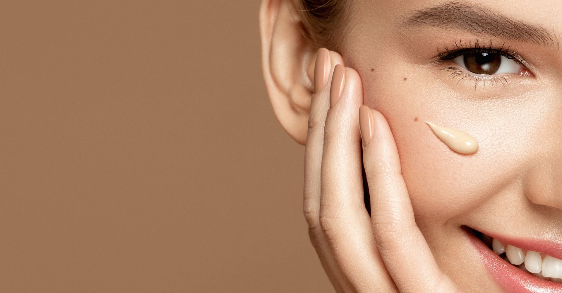 Mulher sorridente com um pingo de protetor solar com cor em sua bochecha.